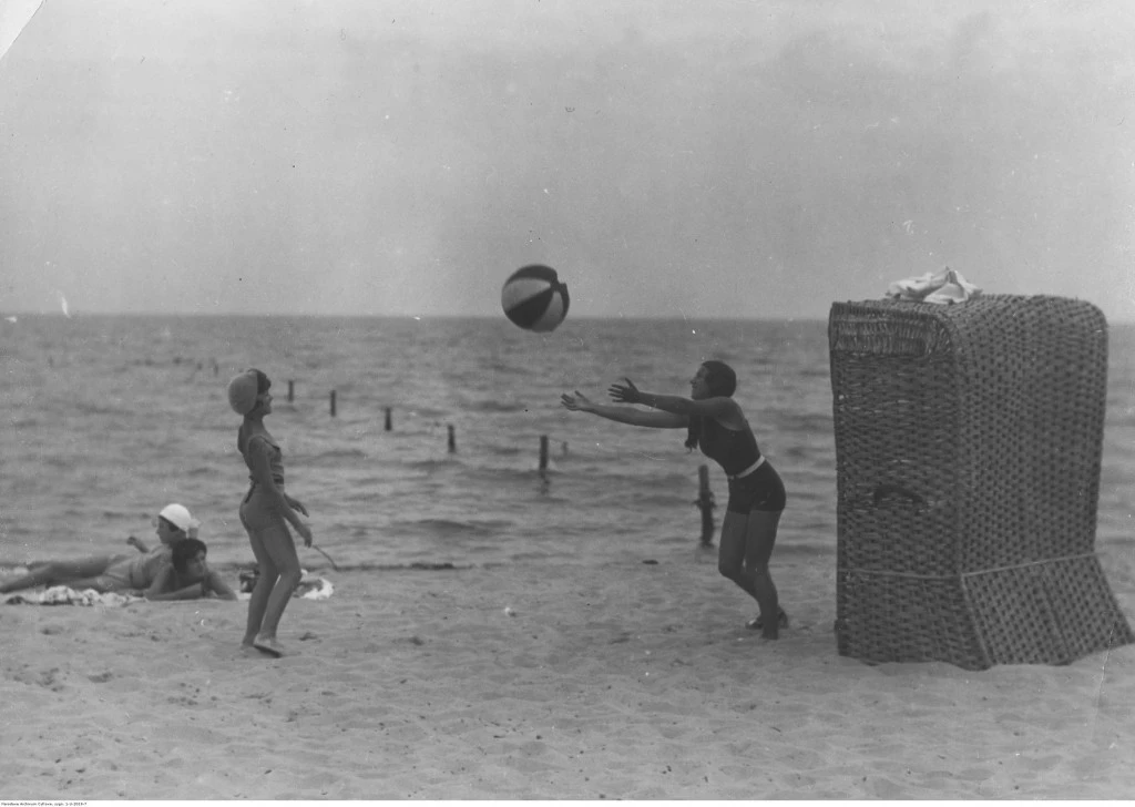 Karwia, plażowicze podczas gry w piłkę obok wiklinowego kosza plażowego, 1932. Źródło: audiovis.nac.gov.pl