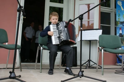 Rodzinne siadanie na trawie z akordeonem