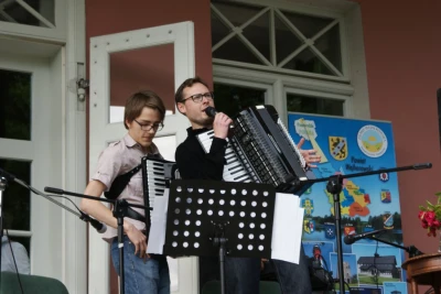Rodzinne siadanie na trawie z akordeonem