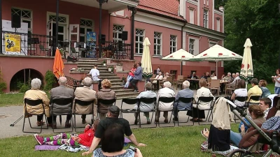 Rodzinne siadanie na trawie z akordeonem